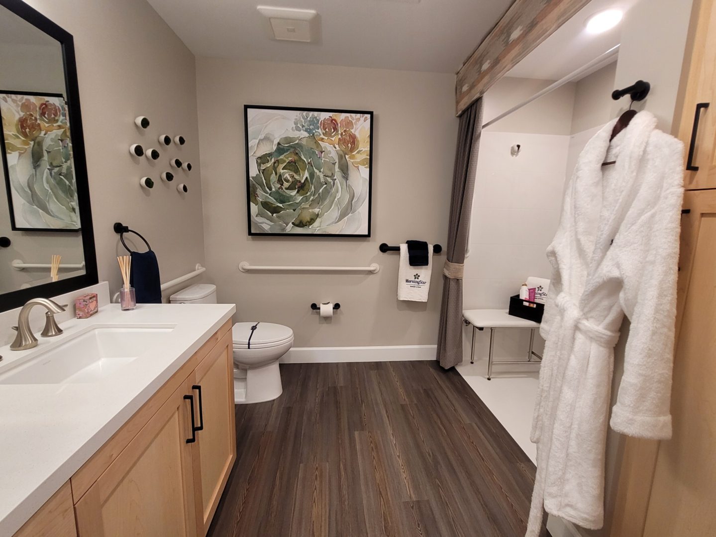 A bathroom with wood floors and white fixtures.