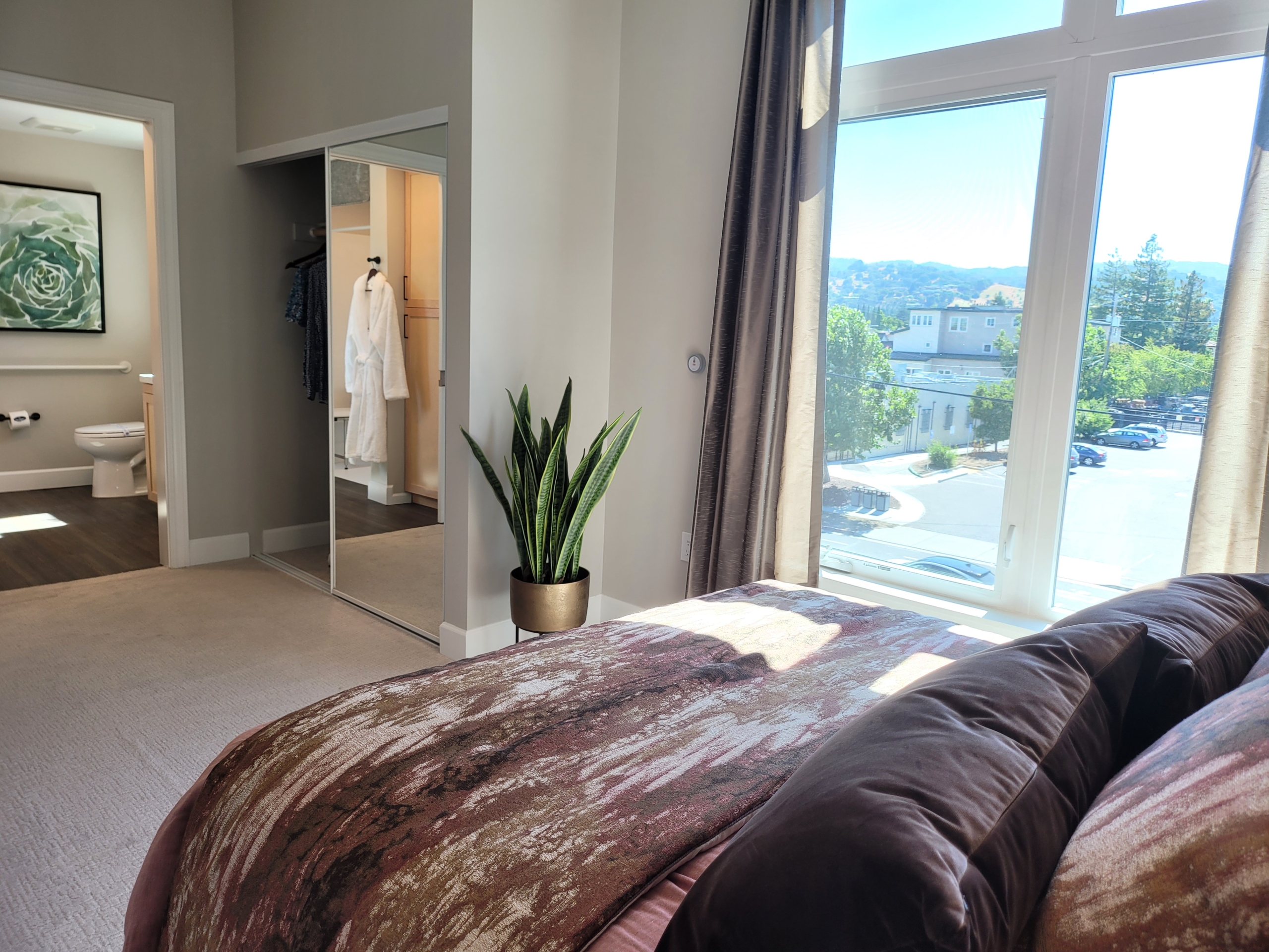 A bedroom with a large window and a view of the mountains.