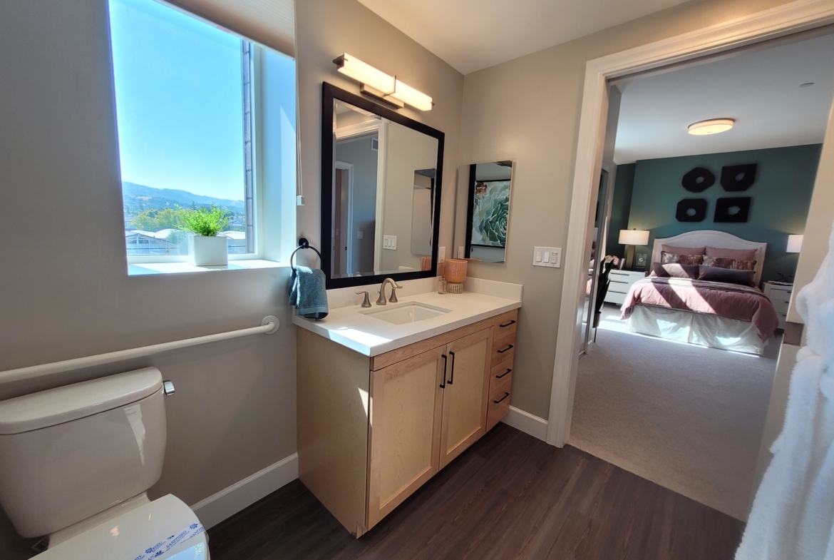 A bathroom with a sink, mirror and toilet.