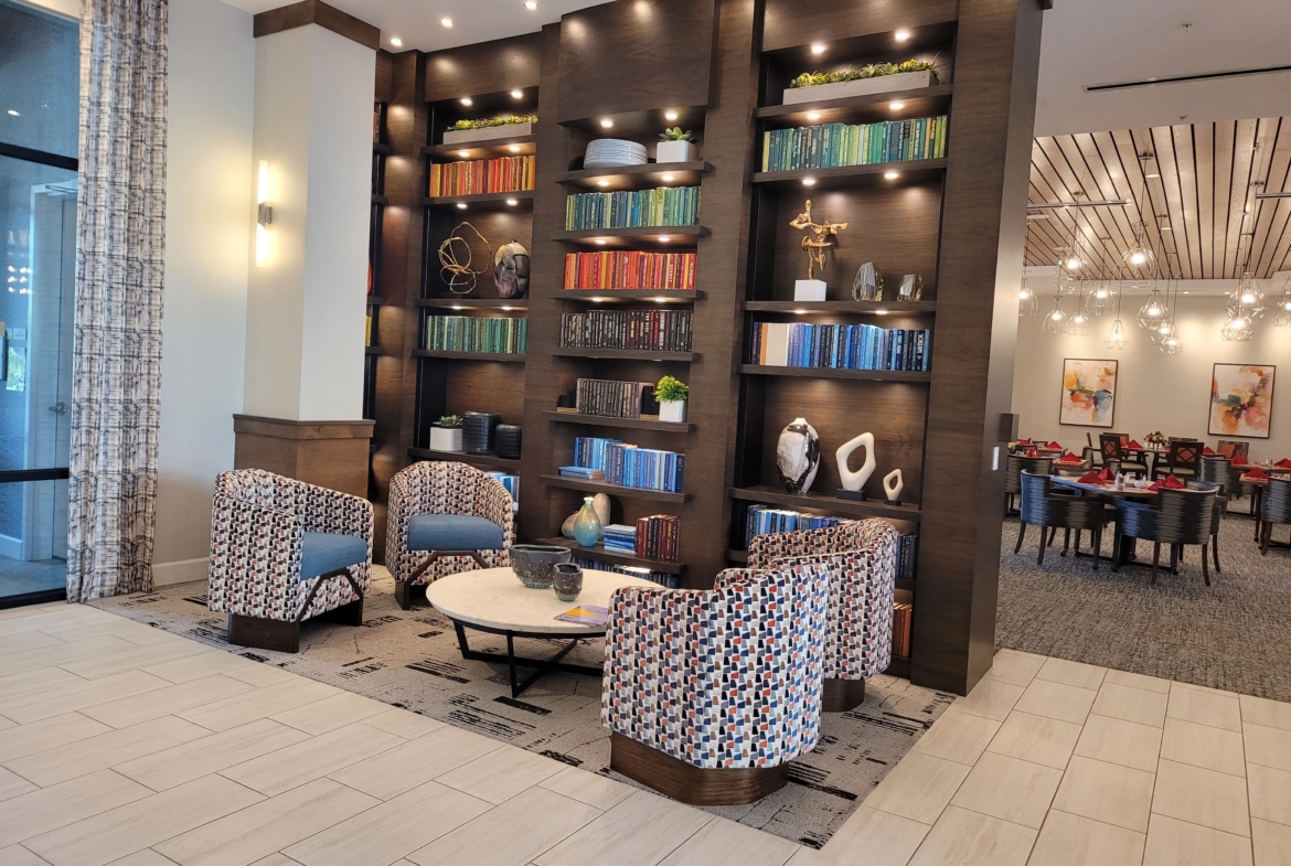 A room with several chairs and shelves of books.