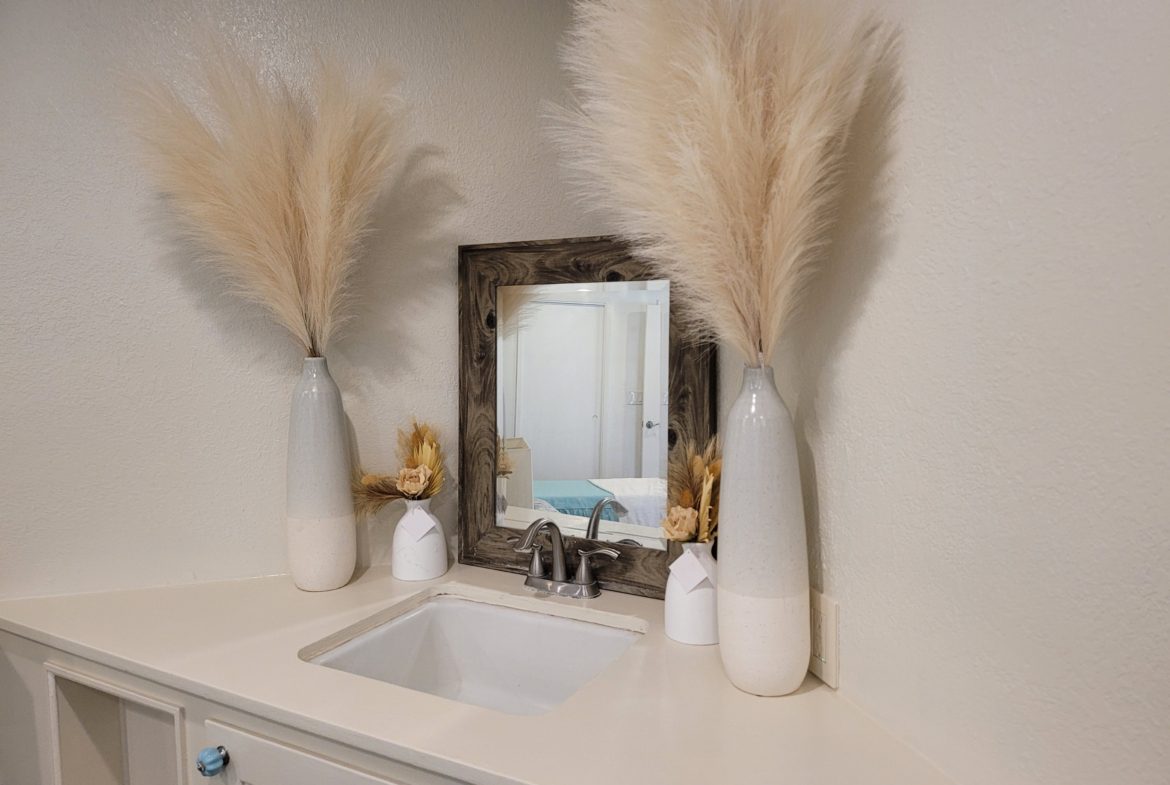 A bathroom with two vases and a mirror