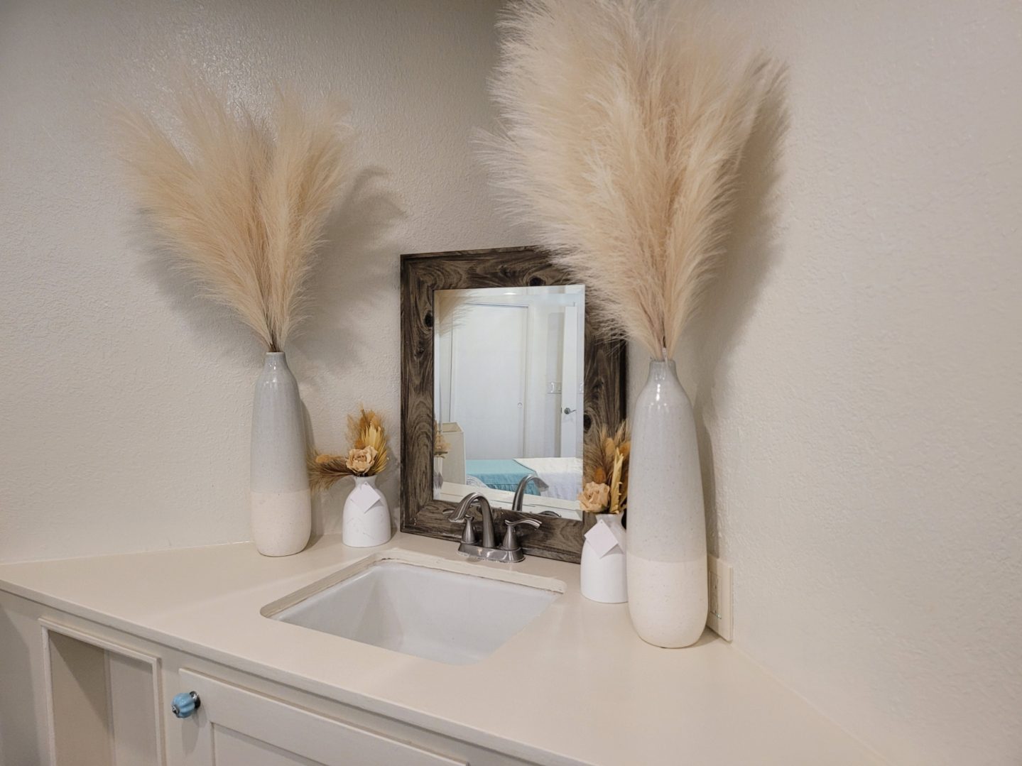 A bathroom with two vases and a mirror