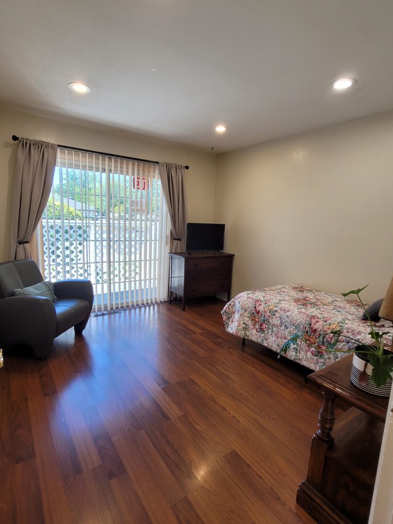 A bedroom with a bed, chair and television.