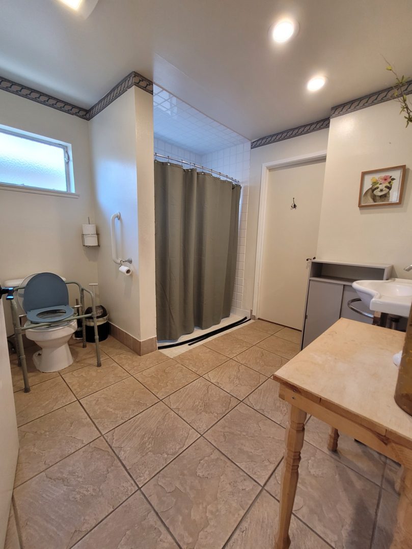 A bathroom with a toilet, sink and shower.