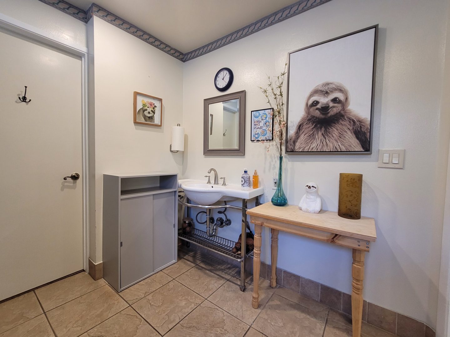 A bathroom with a sink, mirror and table.