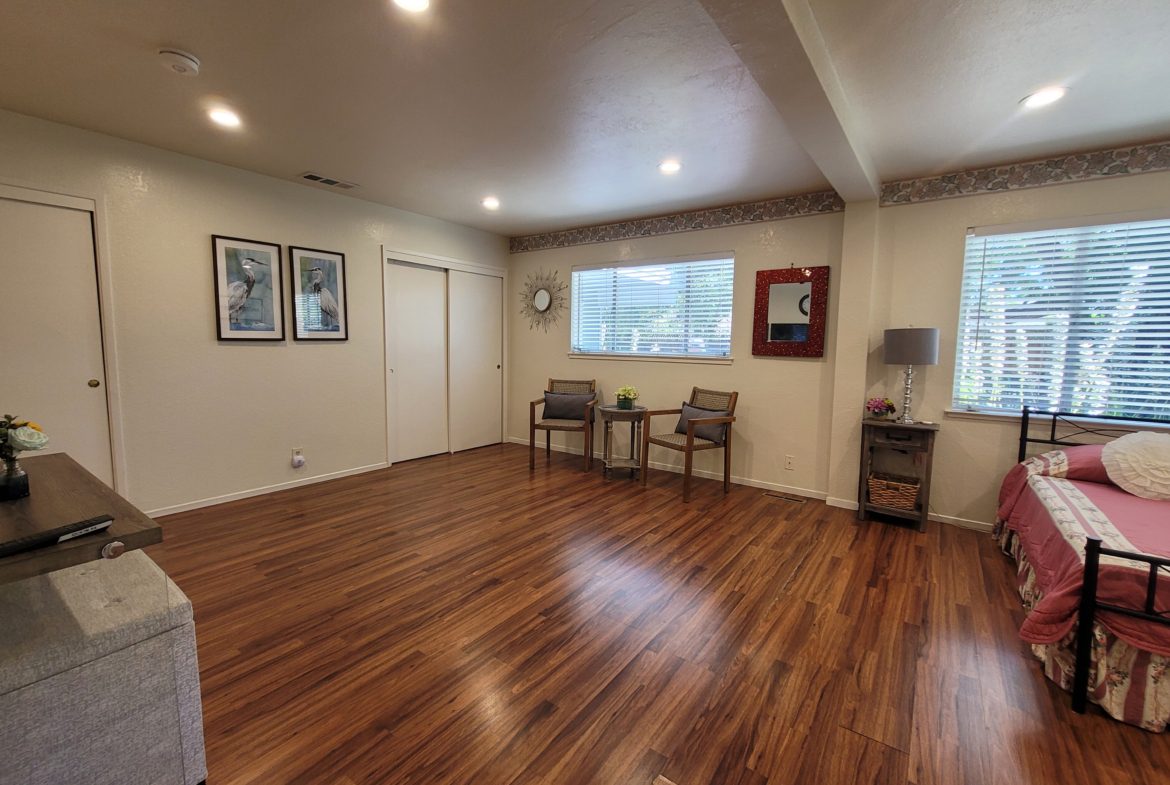 A living room with hard wood floors and white walls.