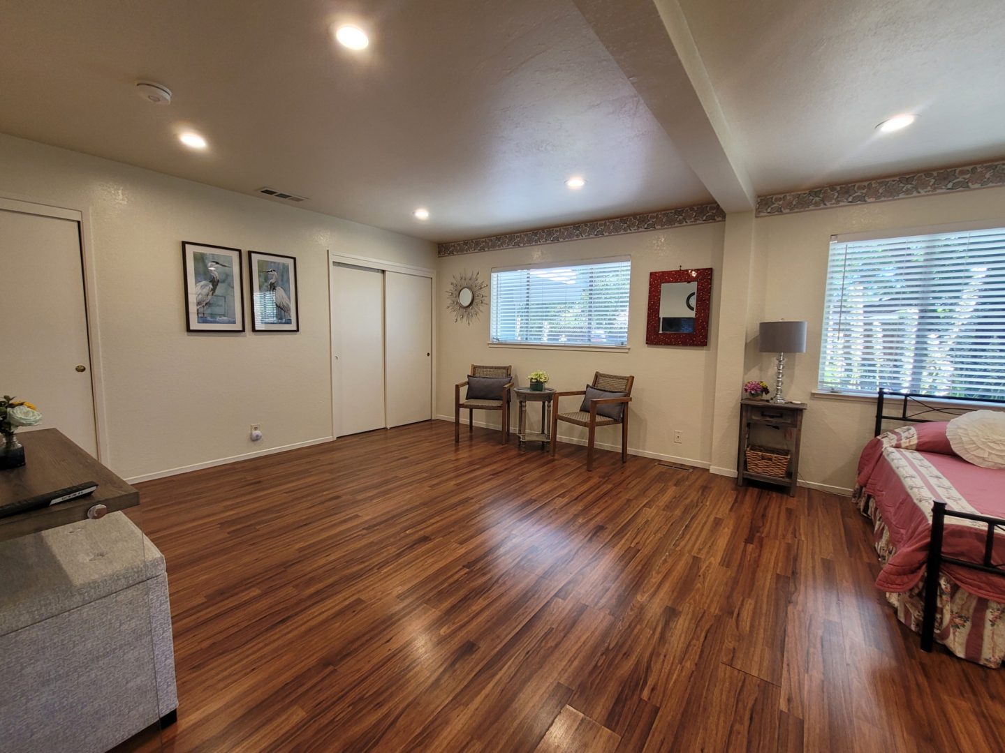 A living room with hard wood floors and white walls.