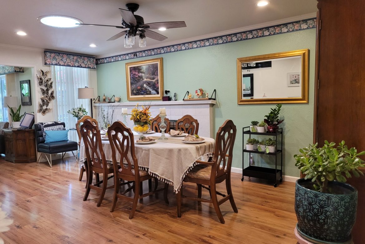 A dining room with wooden floors and white walls.