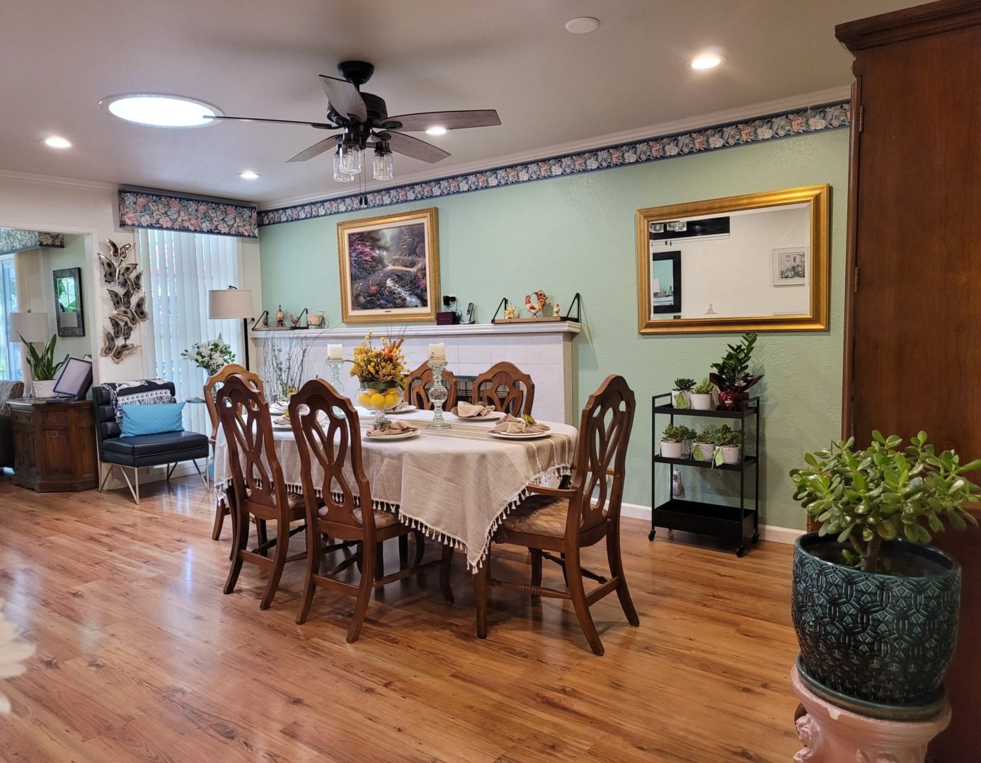 A dining room with wooden floors and white walls.