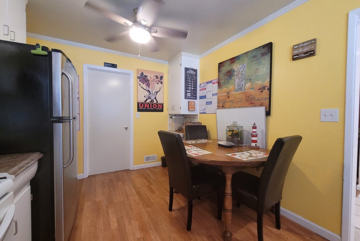 A kitchen with yellow walls and wooden floors.