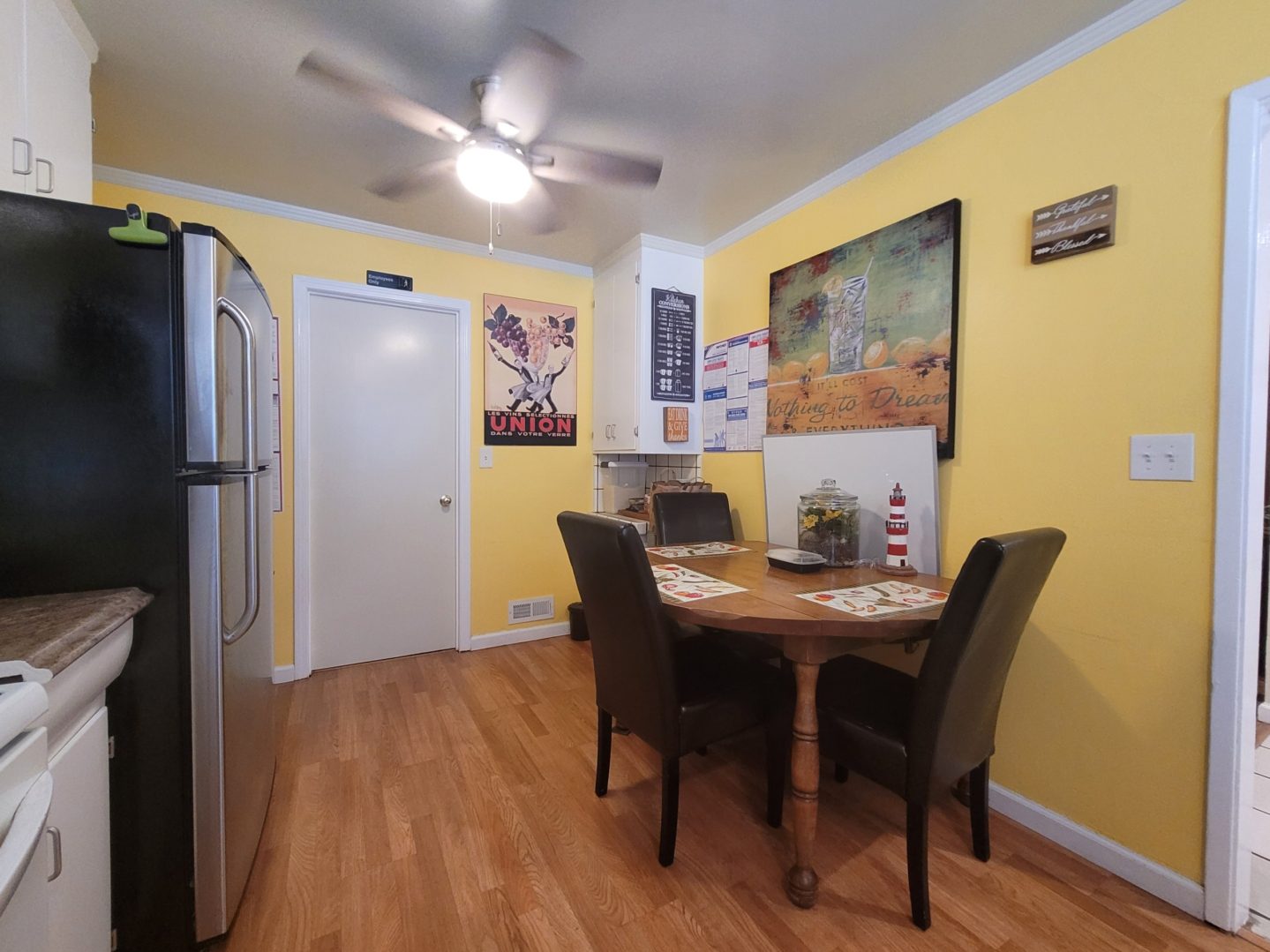 A kitchen with yellow walls and wooden floors.