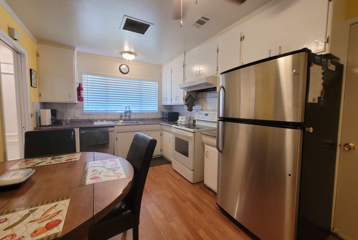 A kitchen with stainless steel appliances and wooden floors.