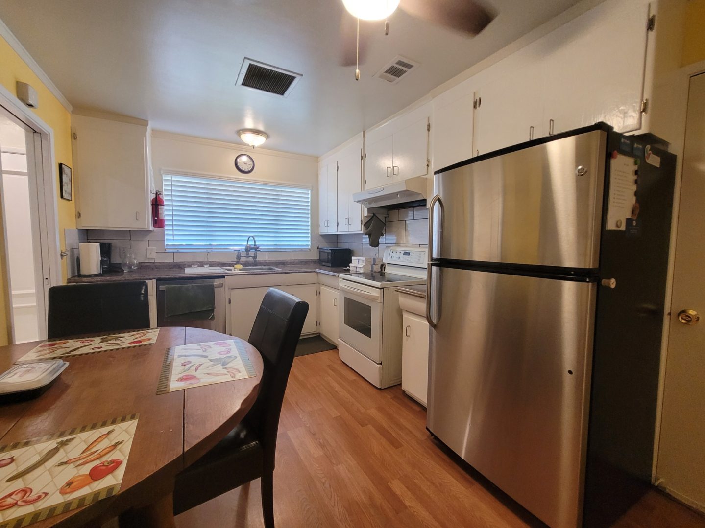 A kitchen with stainless steel appliances and wooden floors.