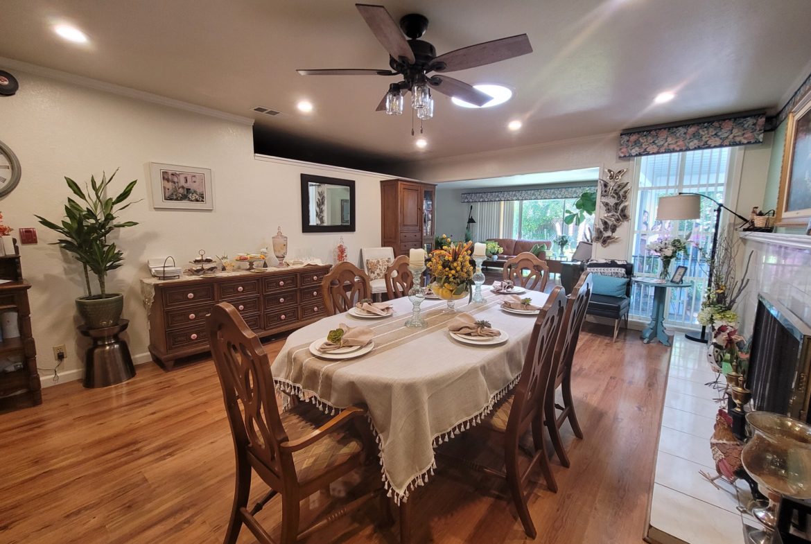 A dining room table with chairs and a fan