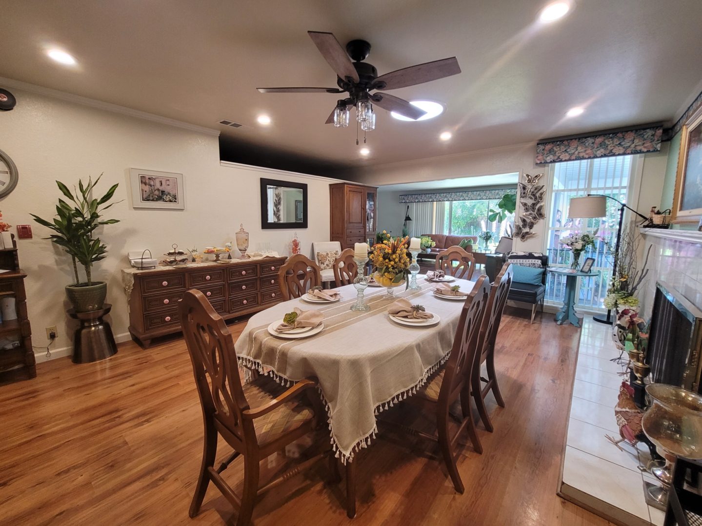 A dining room table with chairs and a fan