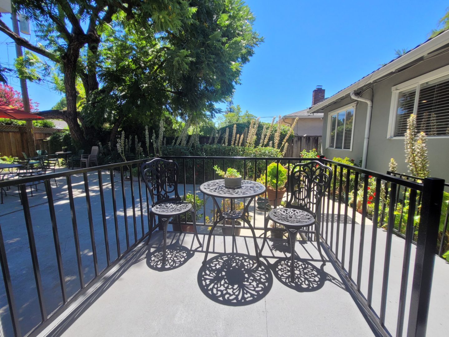 A patio with two tables and chairs on the back deck.