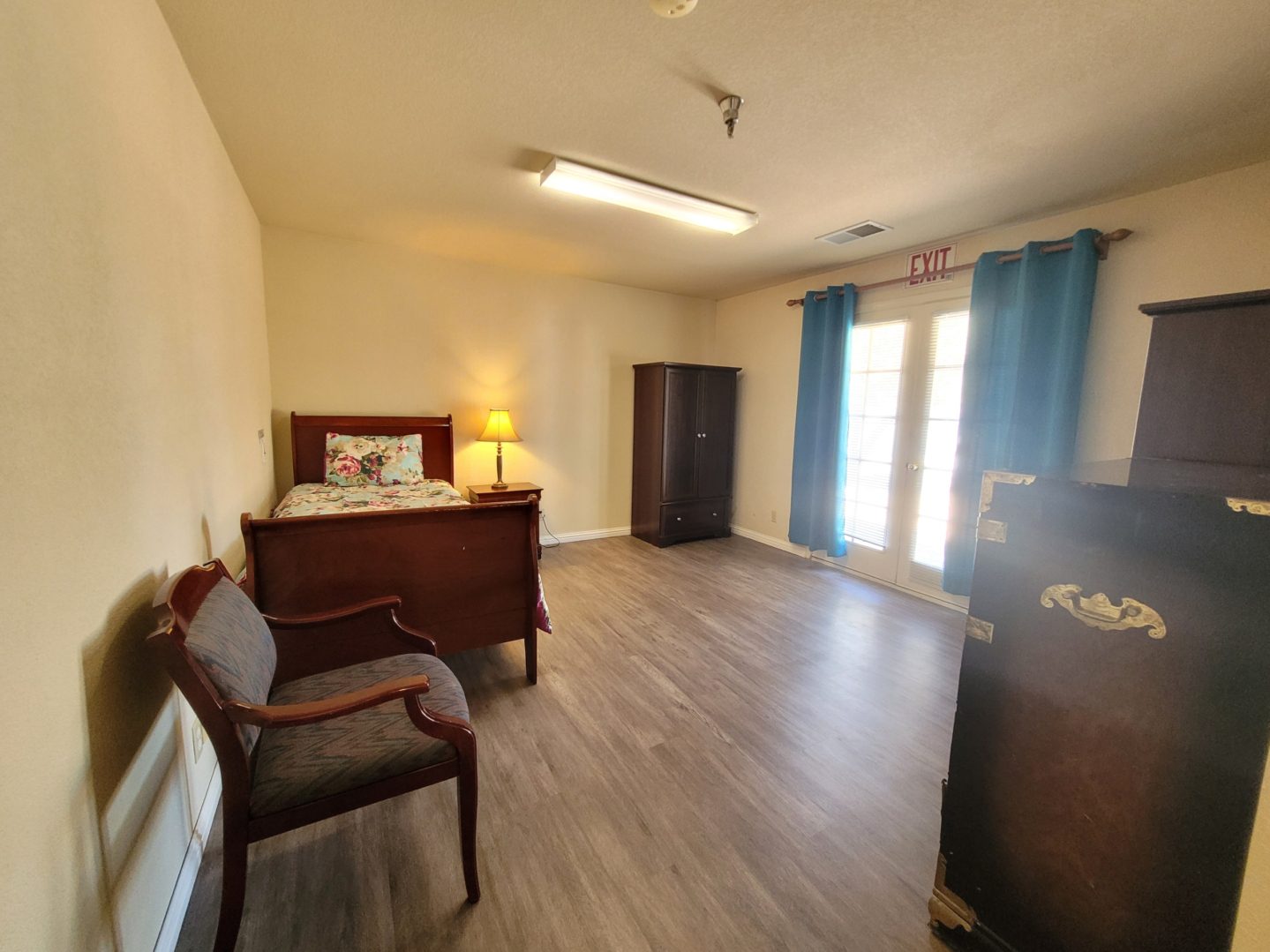 A bedroom with hard wood floors and furniture.