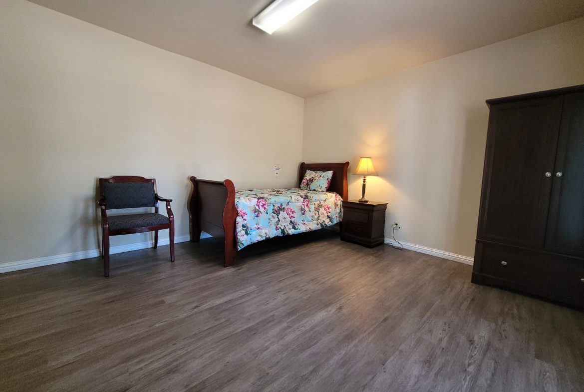 A bedroom with wooden floors and furniture.