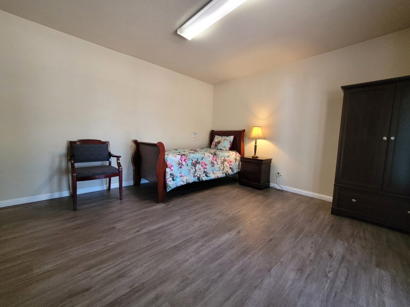 A bedroom with wooden floors and furniture.