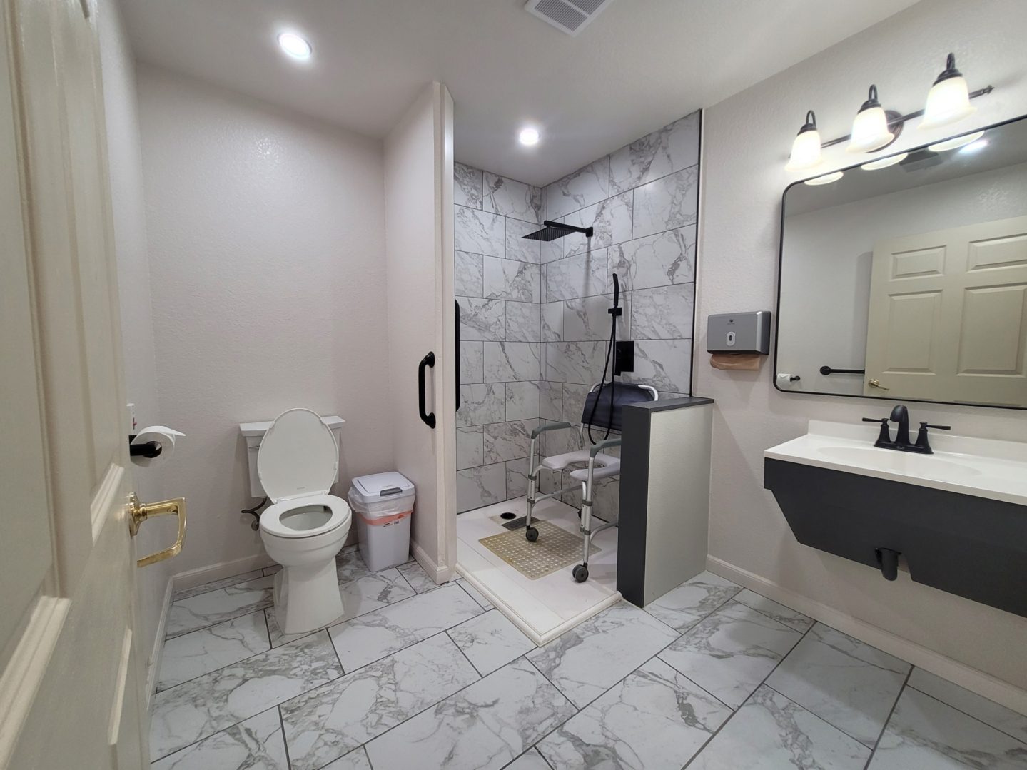 A bathroom with a toilet, sink and mirror.