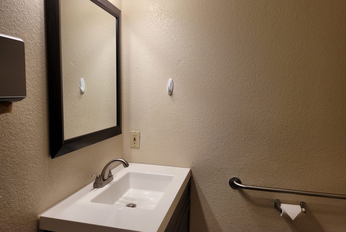 A bathroom with a sink and mirror in it