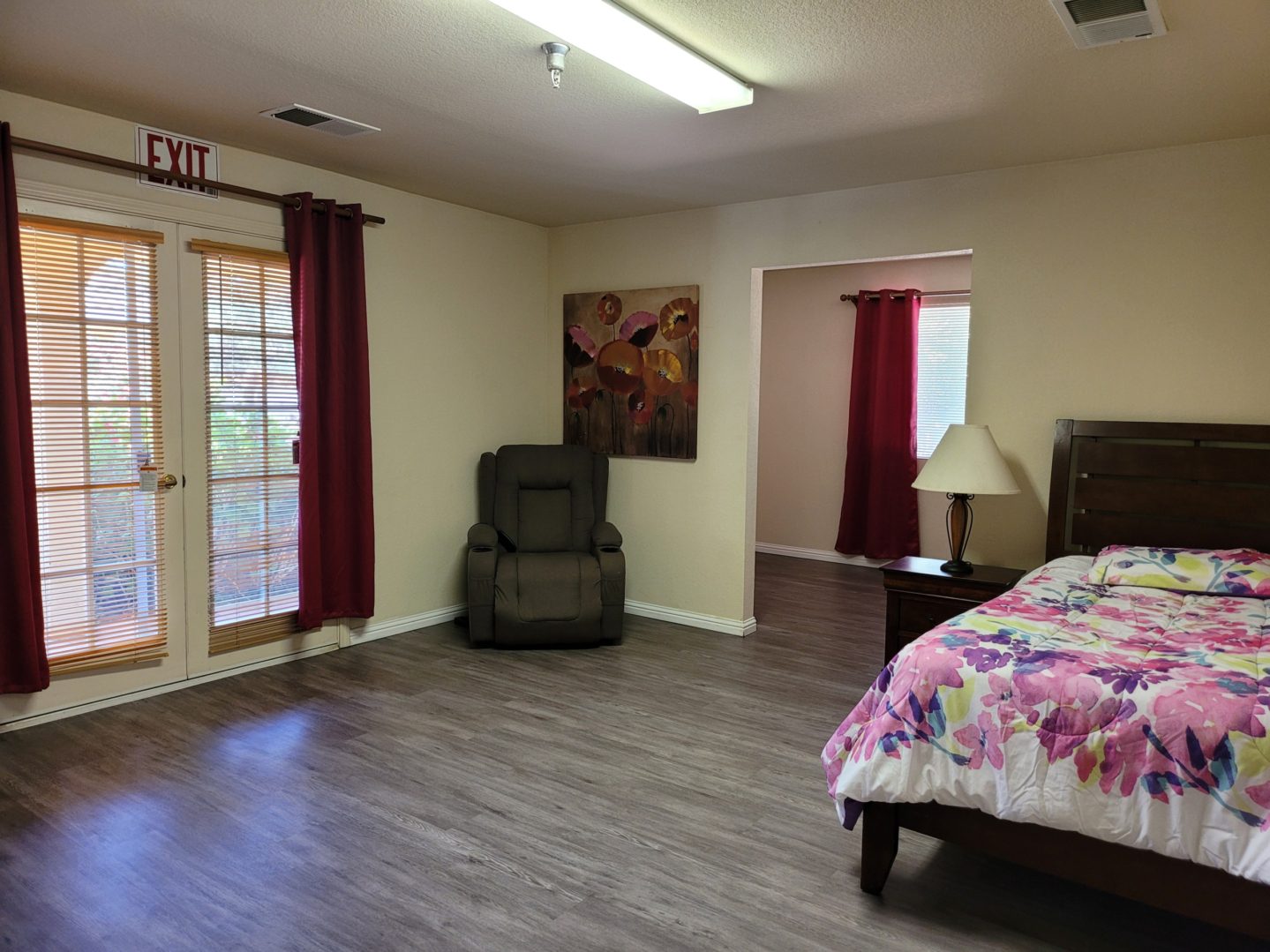 A bedroom with a bed, chair and table.