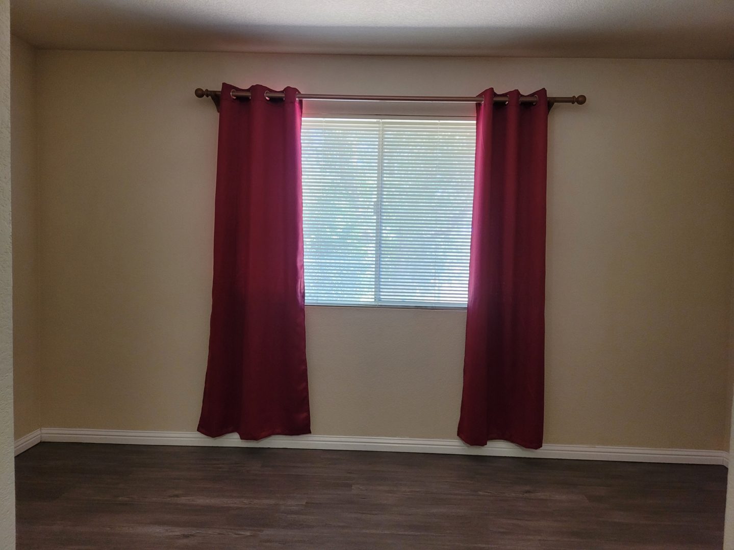 A room with two windows and a wooden floor.