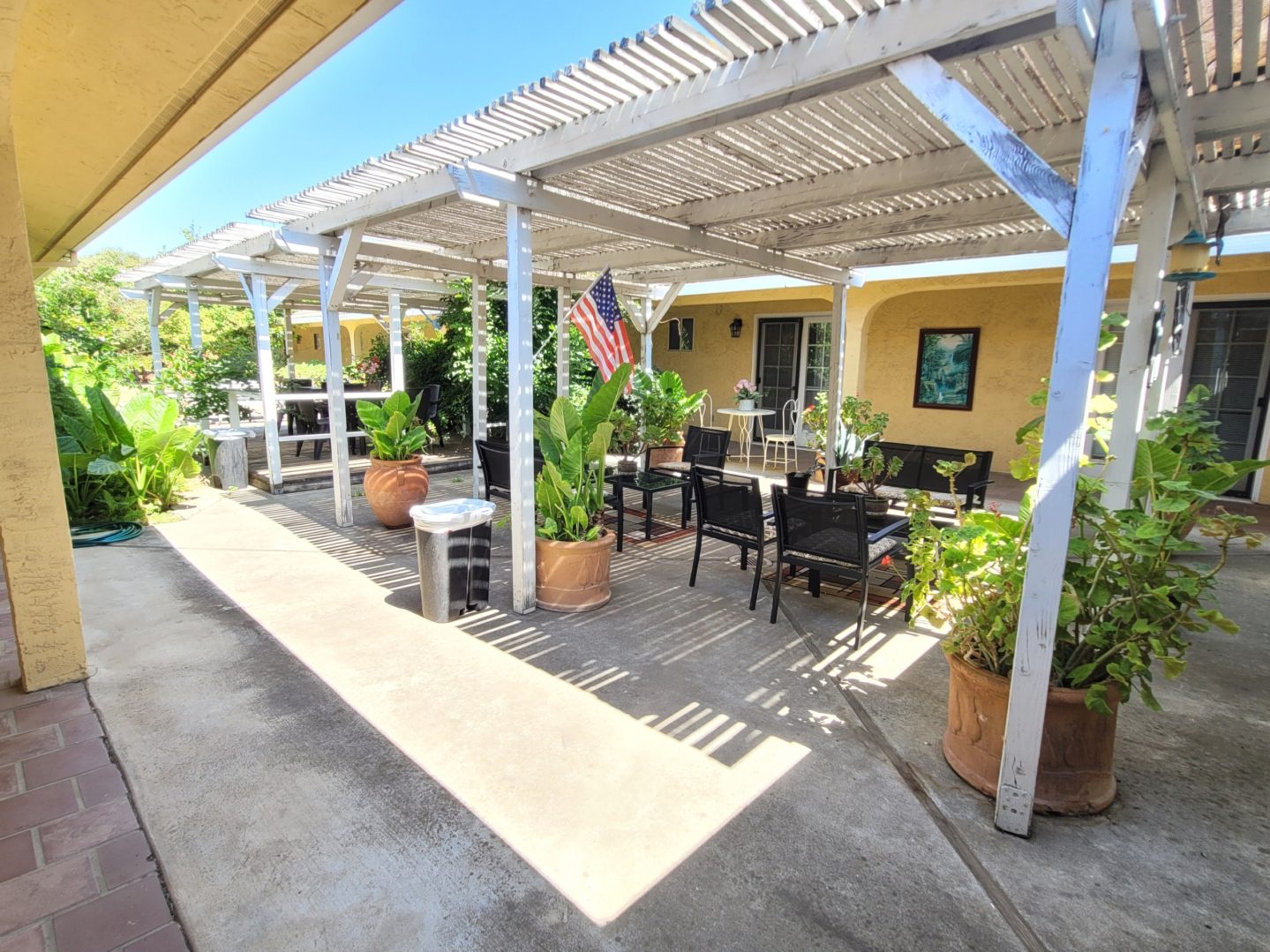 A patio with tables and chairs under an awning.