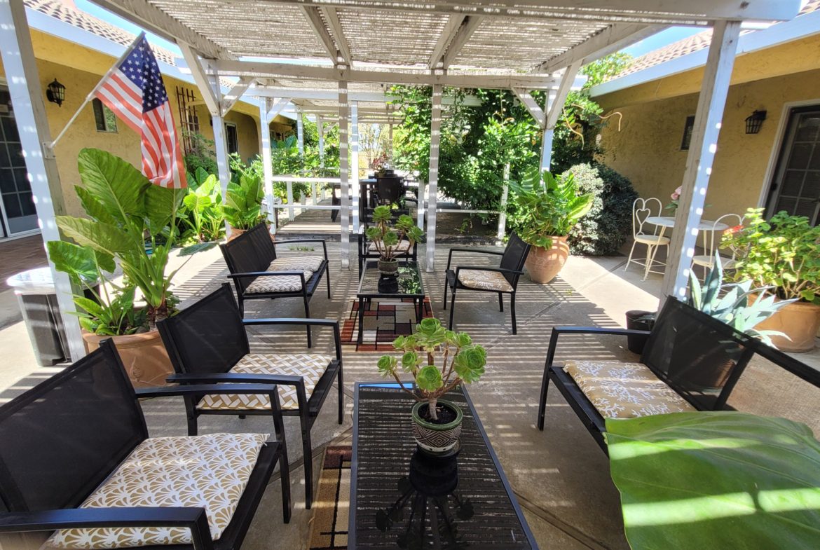 A patio with many chairs and tables in it