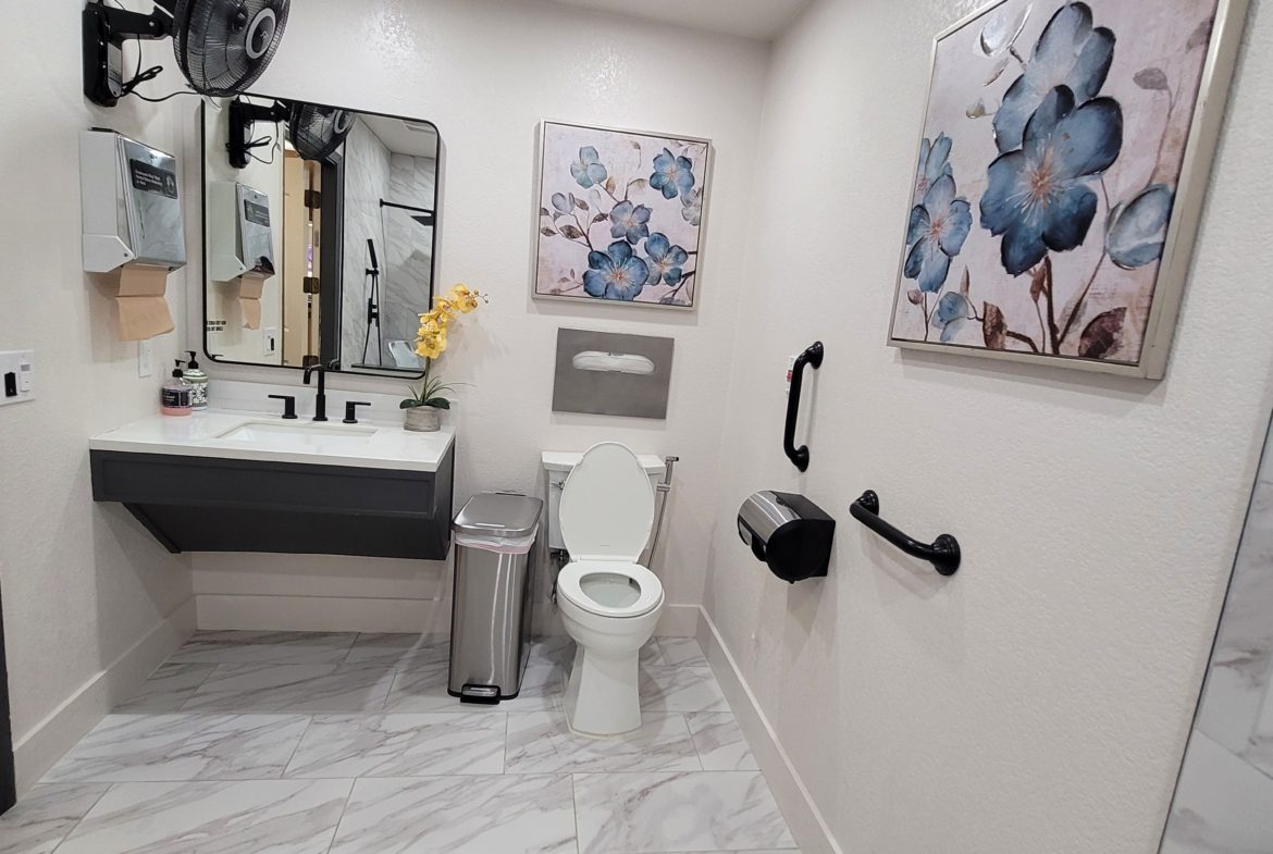 A bathroom with marble floors and walls.