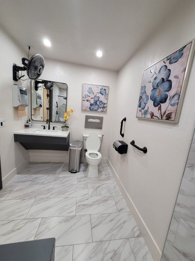 A bathroom with marble floors and walls.