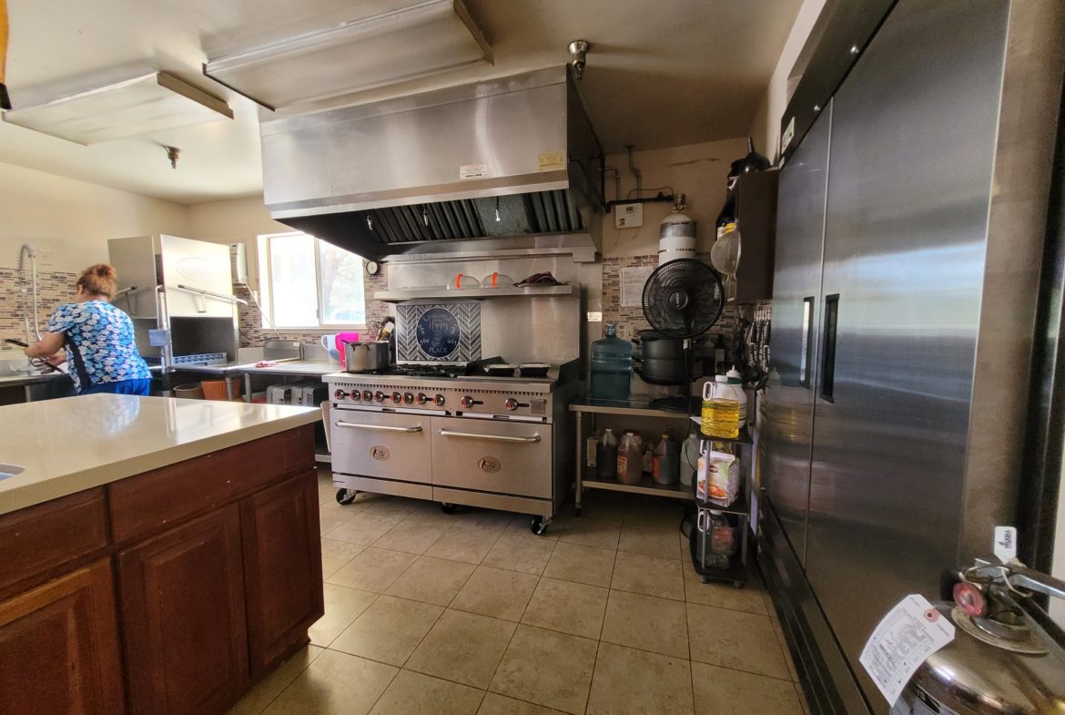 A kitchen with a large stove and many appliances.