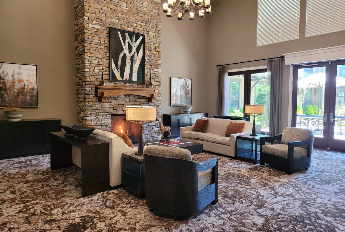 A living room with couches, chairs and tables.