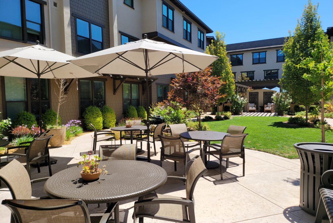 A patio with tables and chairs outside of a building.