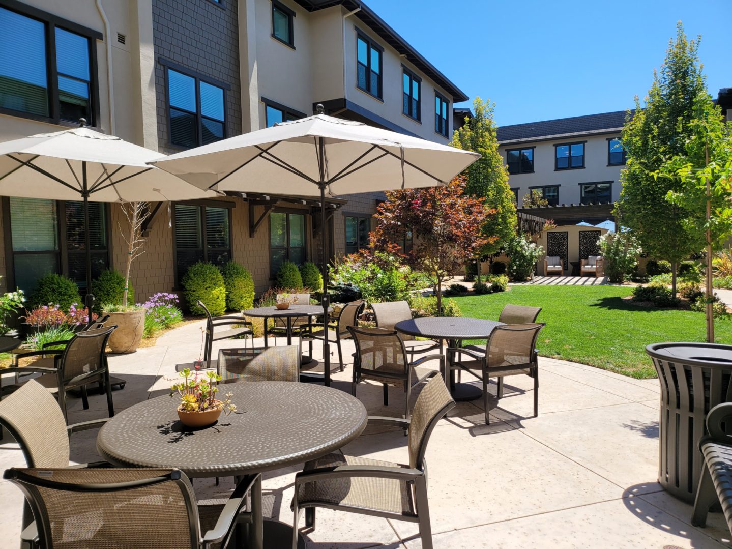 A patio with tables and chairs outside of a building.