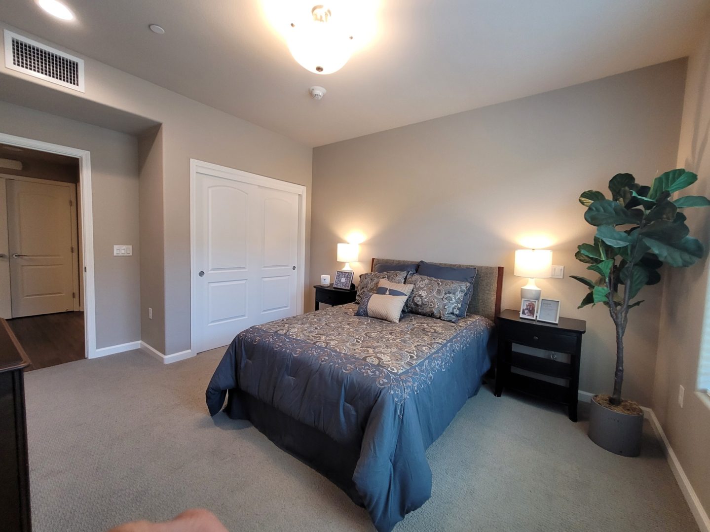 A bedroom with a bed, nightstand and dresser.