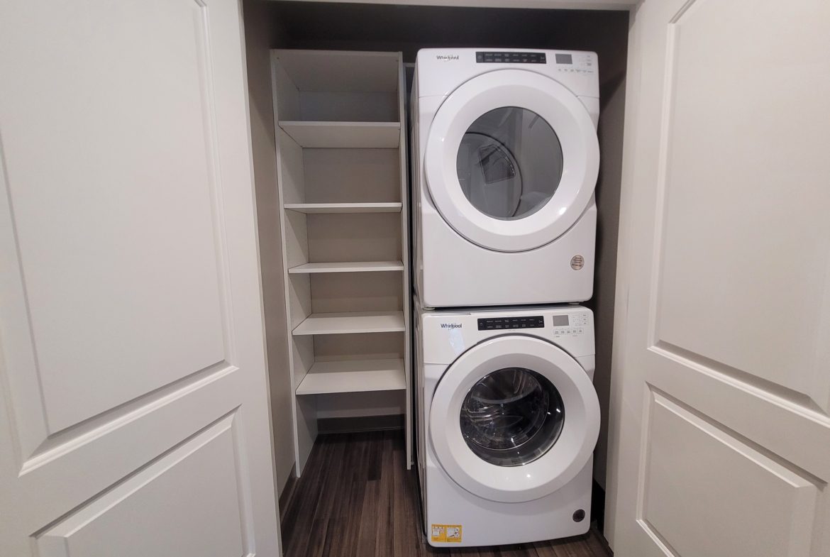 A white washer and dryer in the corner of a room.