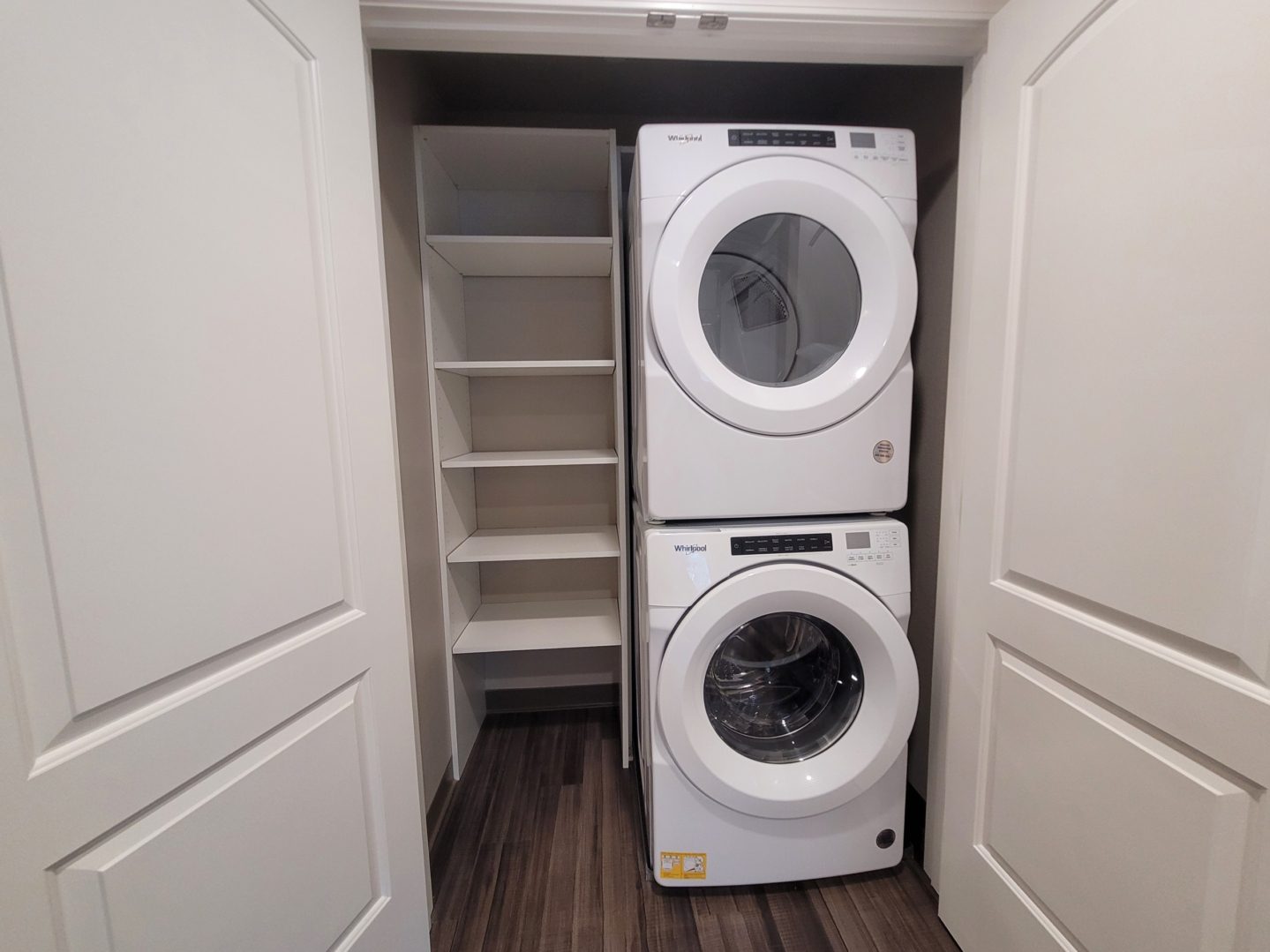 A white washer and dryer in the corner of a room.