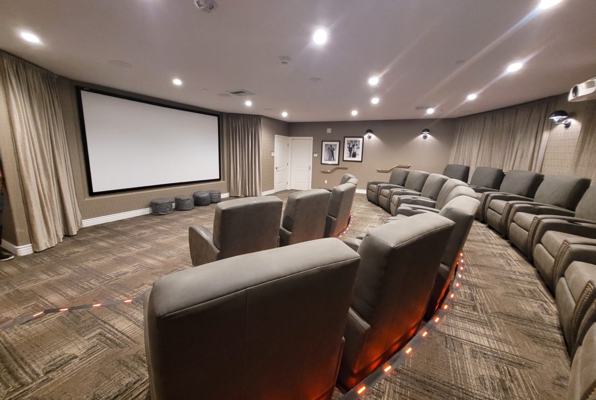 A large room with many chairs and a projector screen.