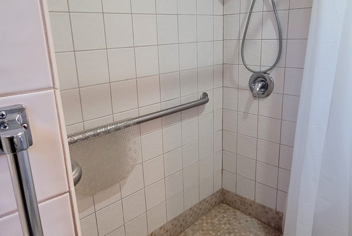 A shower with tile walls and floor in the bathroom.