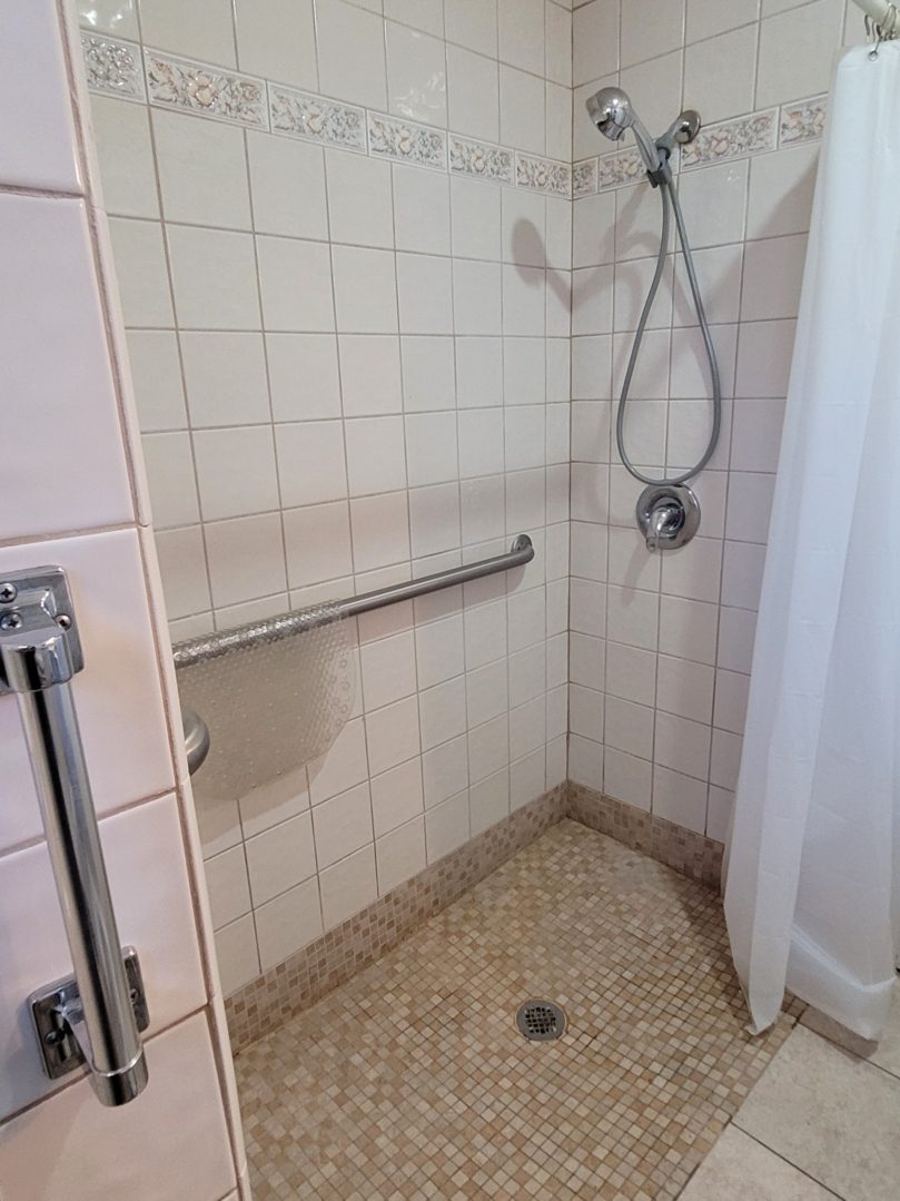 A shower with tile walls and floor in the bathroom.