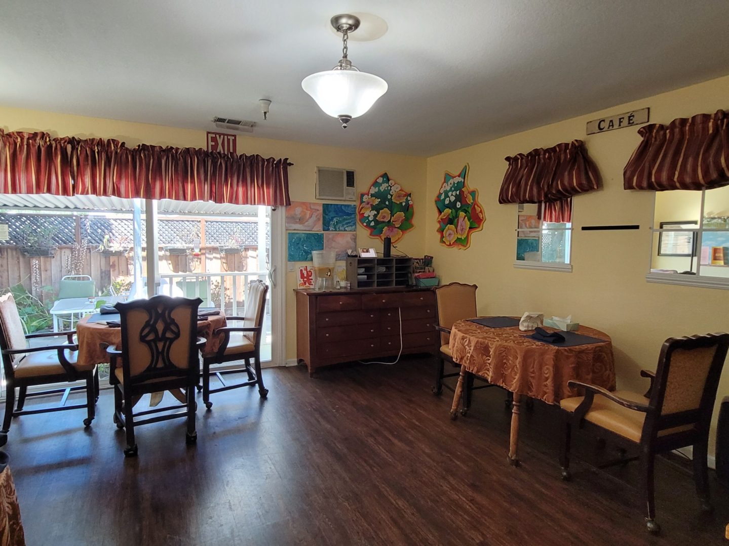 A room with wooden floors and walls, a table and chairs.