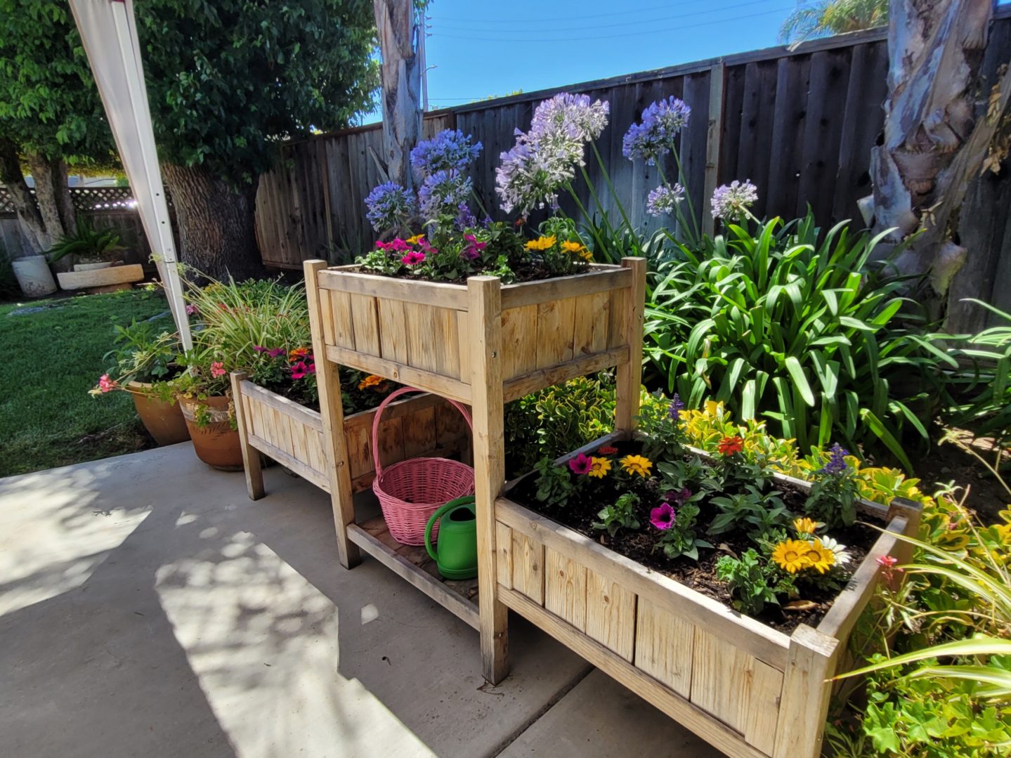 A couple of wooden planters filled with flowers.