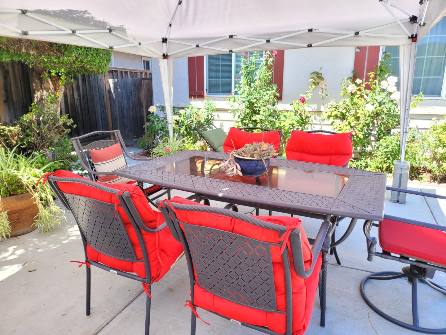 A table and chairs set up outside under an umbrella.