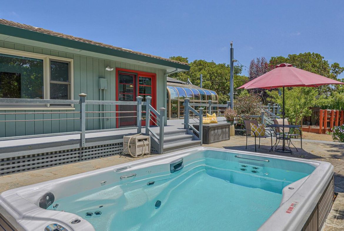 A pool with an umbrella in the background.