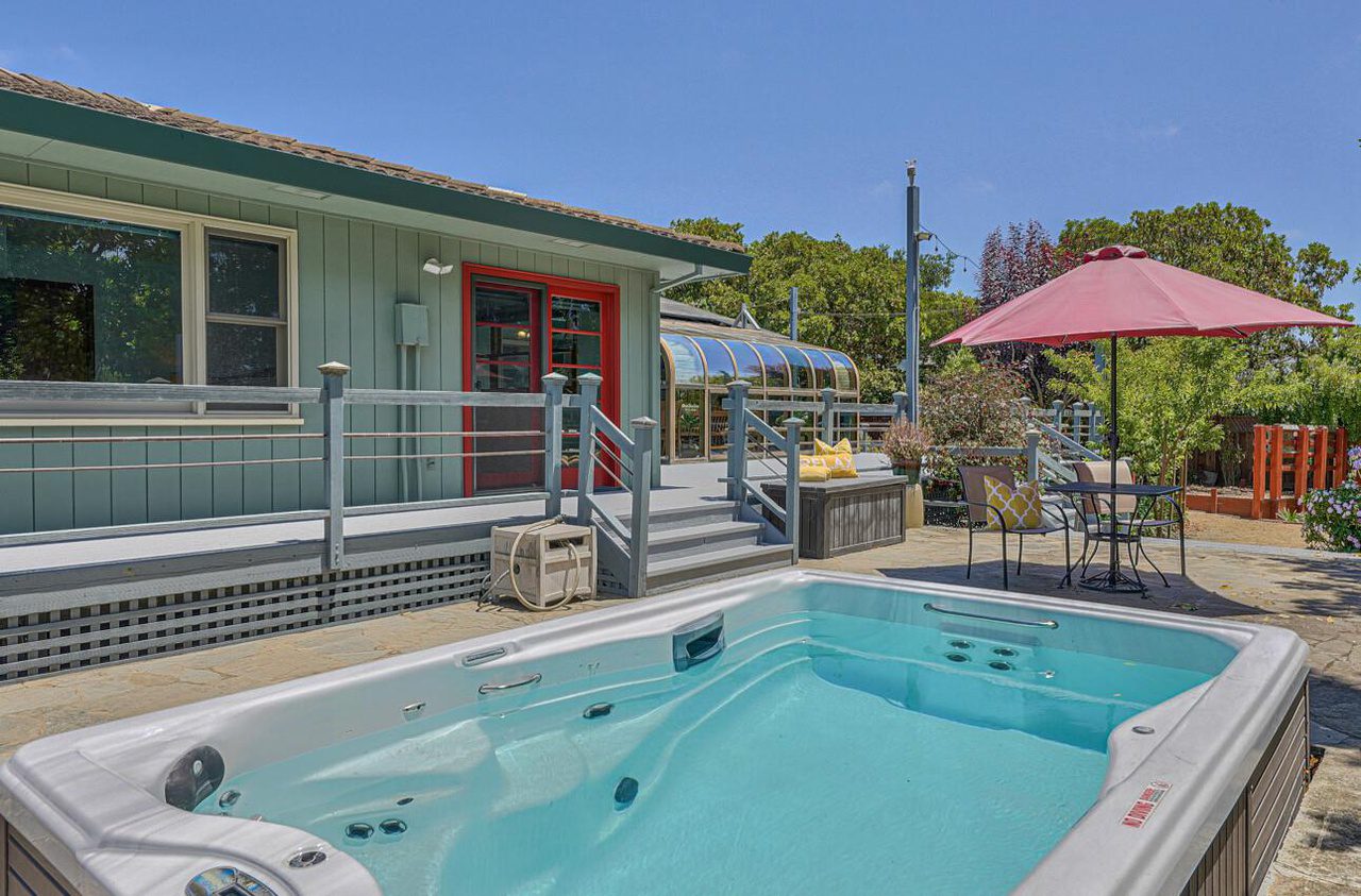 A pool with an umbrella in the background.