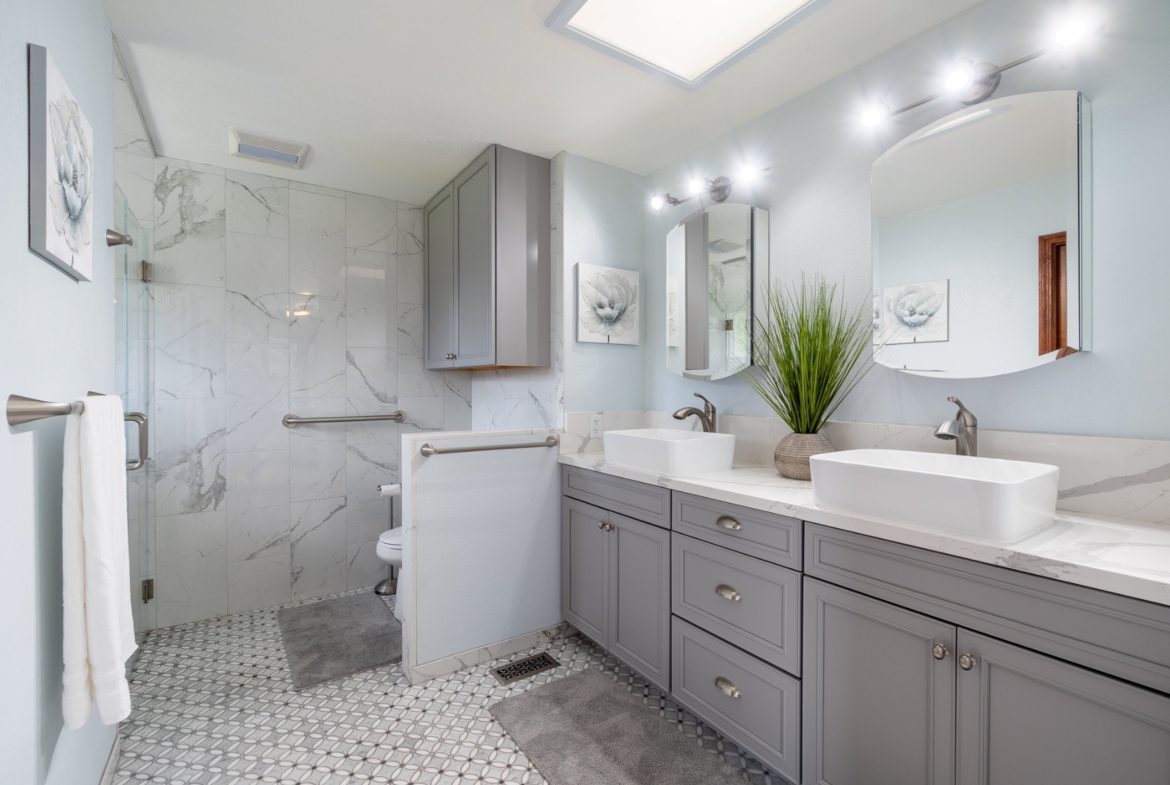 A bathroom with two sinks and a walk in shower.