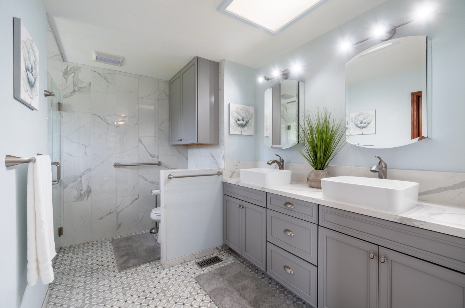 A bathroom with two sinks and a walk in shower.