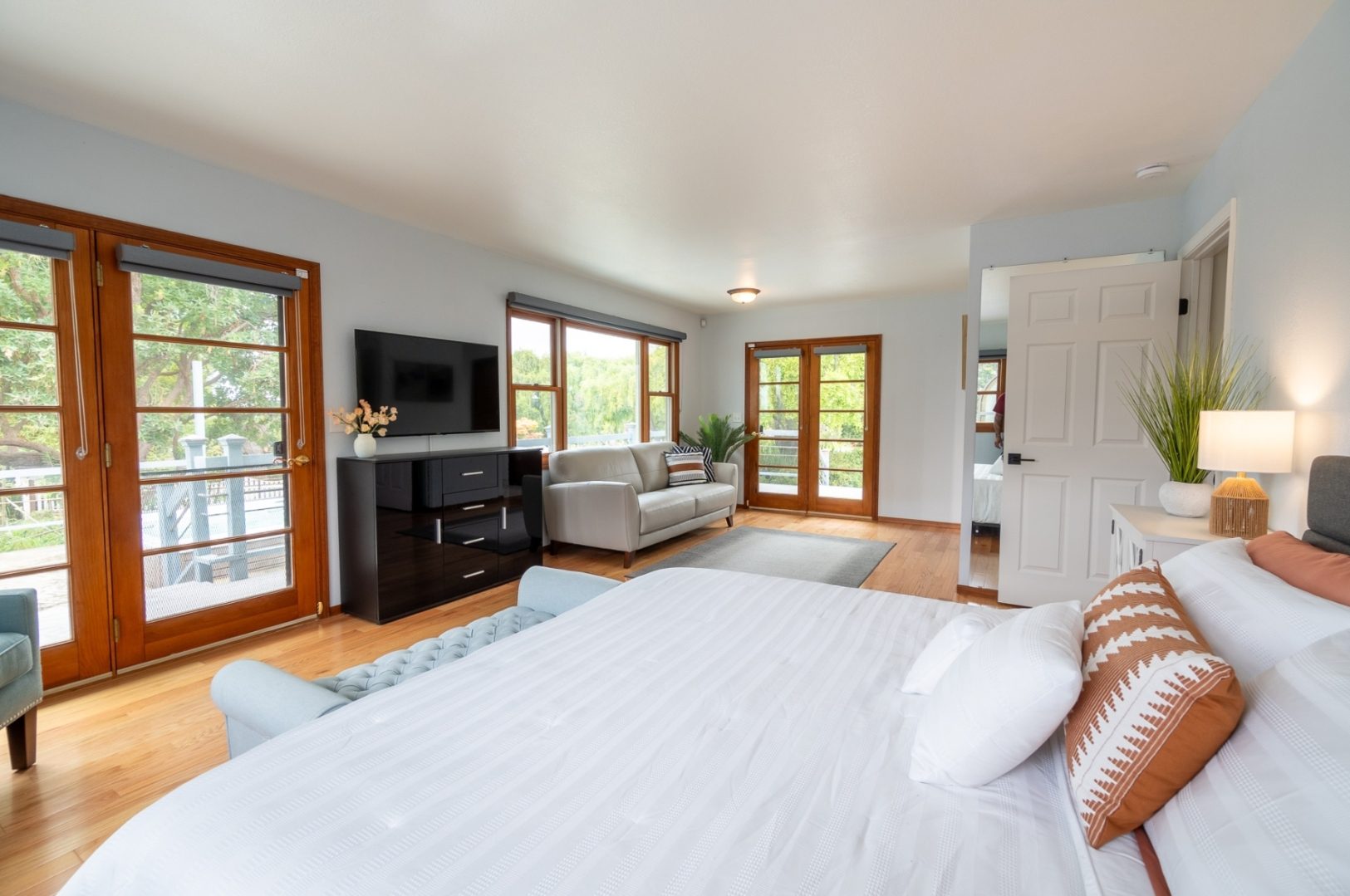 A bedroom with a bed, tv and couch in it.