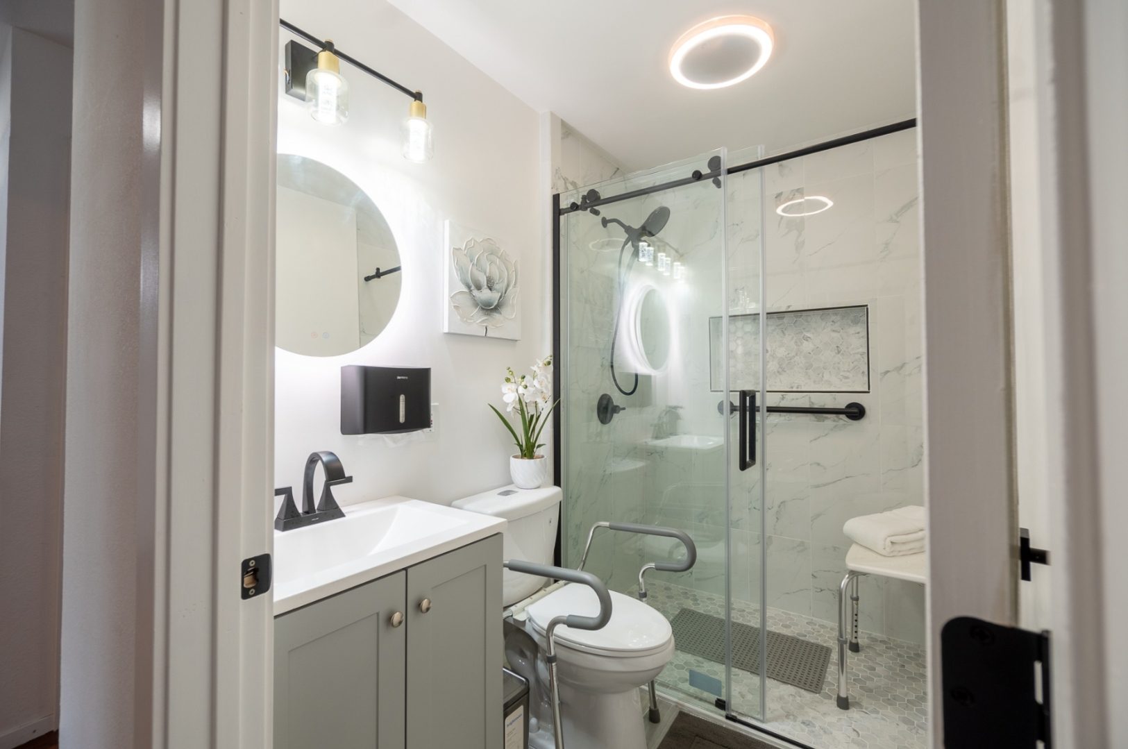 A bathroom with a toilet, sink and shower.